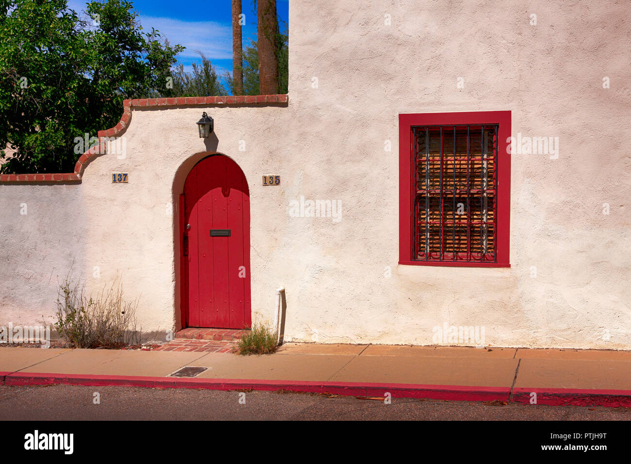 Red door and window frame of an artisan style house in Old Town Tucson