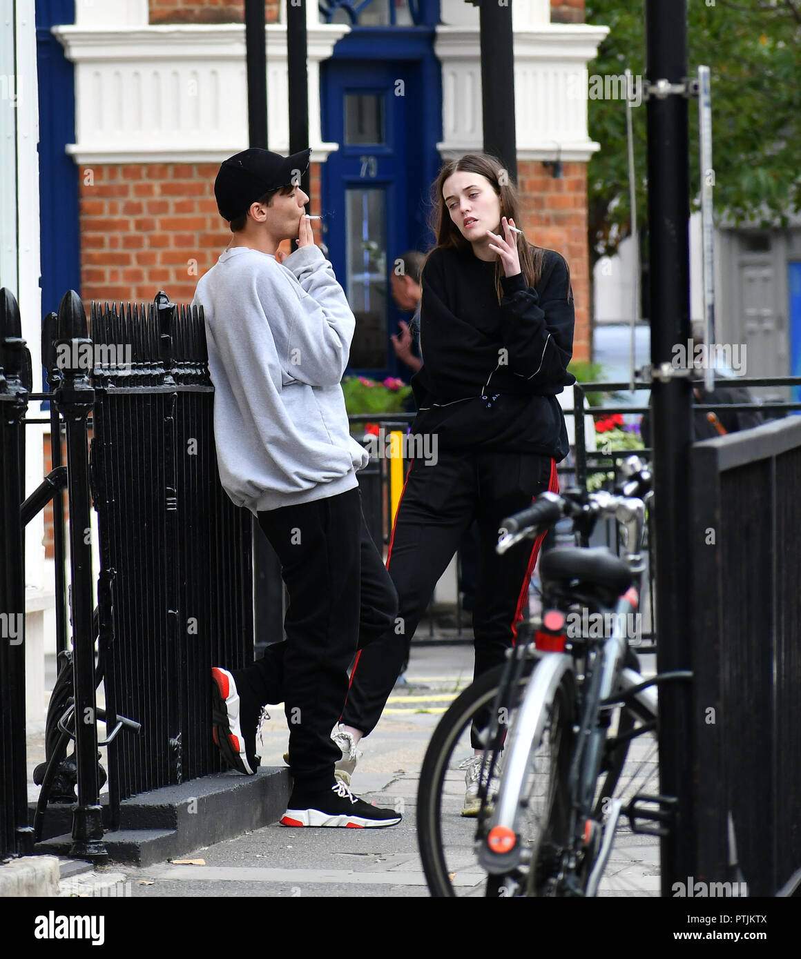 Louis Tomlinson and his sister Felicite Tomlinson aka 'Fizzy' have a  cigarette on Belgravia Street Featuring: