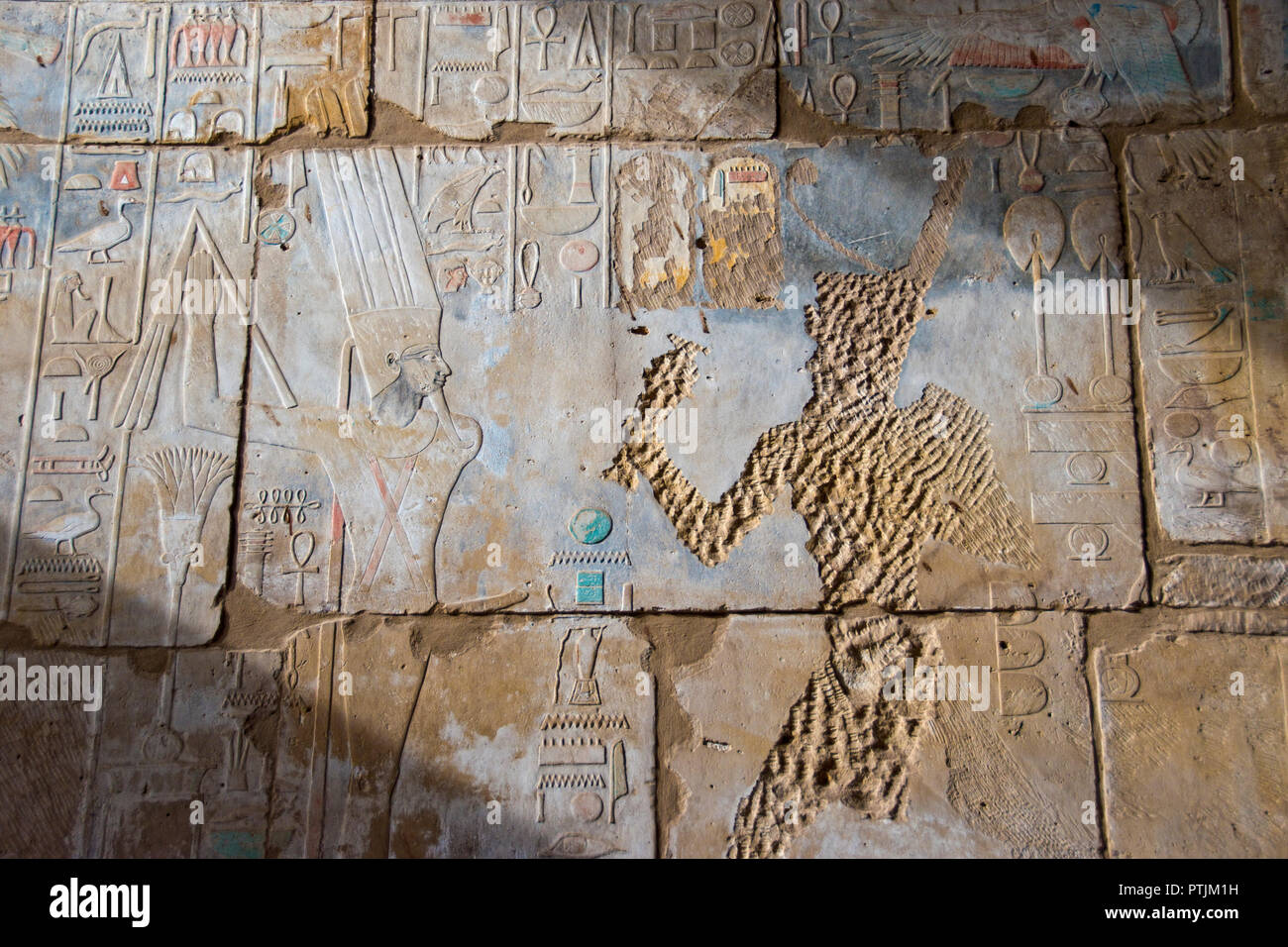 Early Christians defaced many of the brightly painted, bas relief stone images of Egyptian gods and pharaohs inside Karnak Temple at Luxor, Egypt. Stock Photo