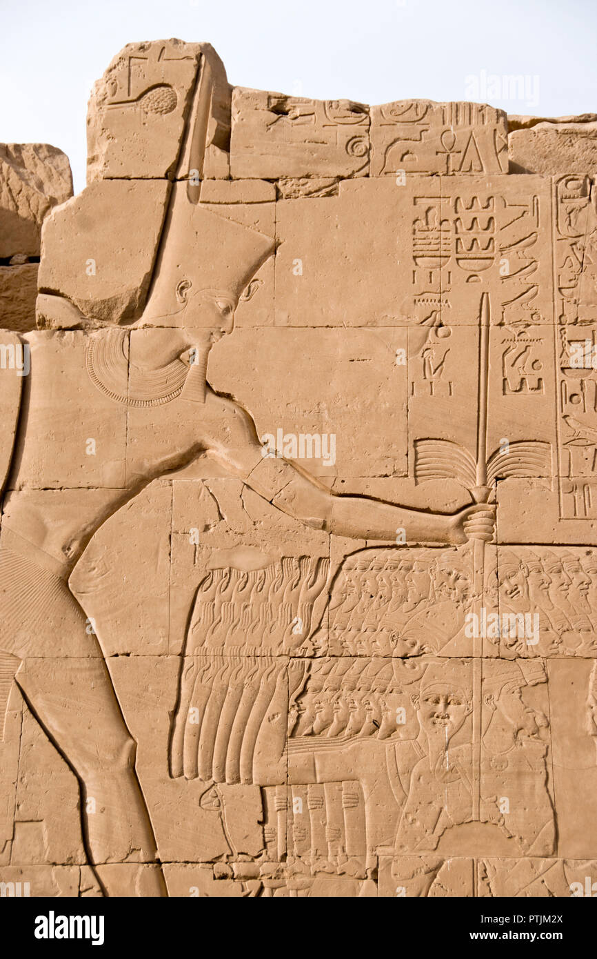 A bas-relief carving of Pharaoh Thutmose III slaying Canaanite captives from the Battle of Megiddo, at Karnak Temple, Luxor, Egypt. Stock Photo