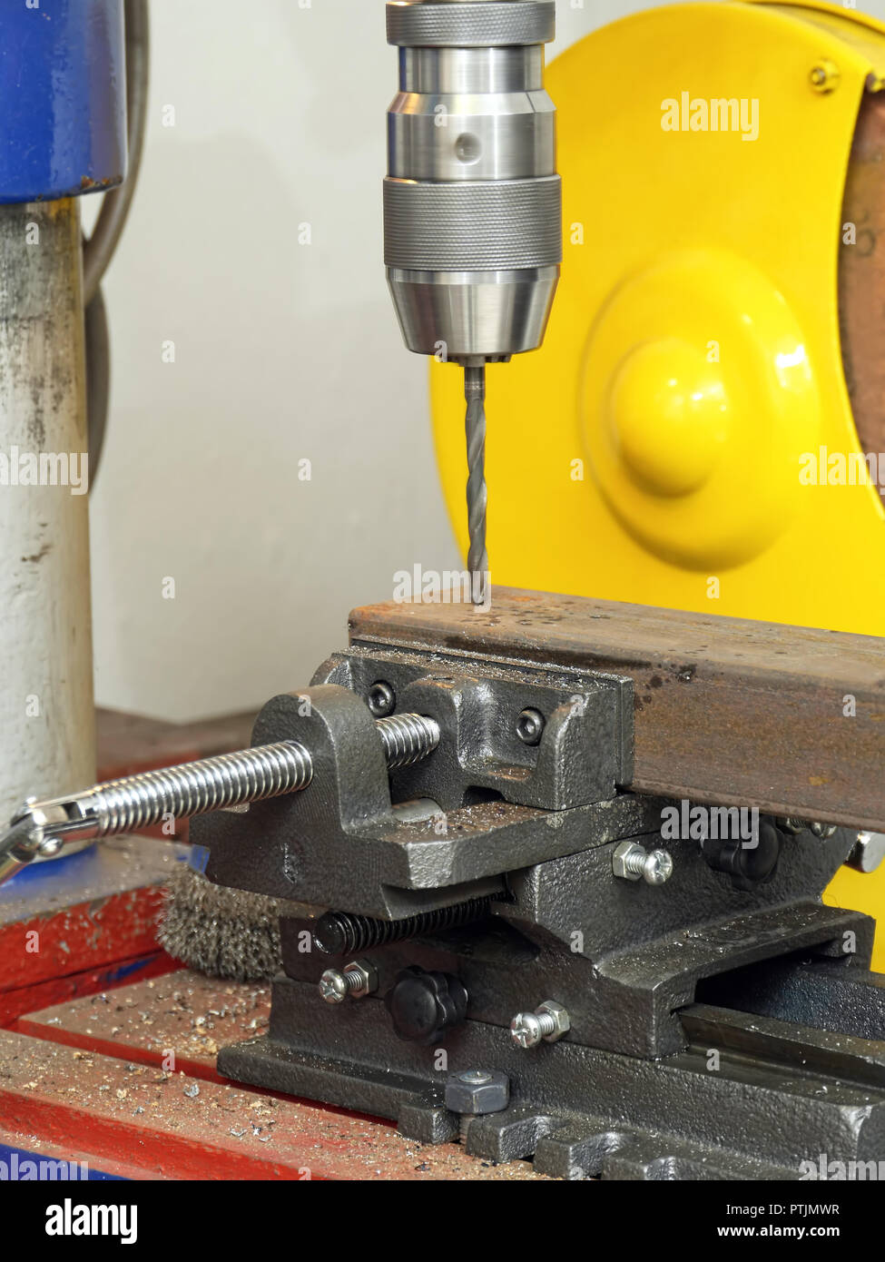 Stationary drilling machine with attached drill bit drilling a hole in