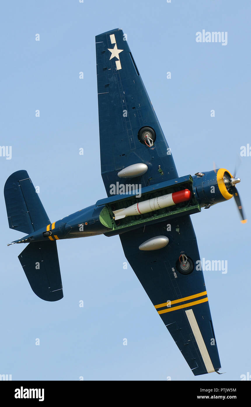 Grumman TBM Avenger flying at an airshow with bomb bay open revealing torpedo. Second World War torpedo bomber flying in blue sky Stock Photo