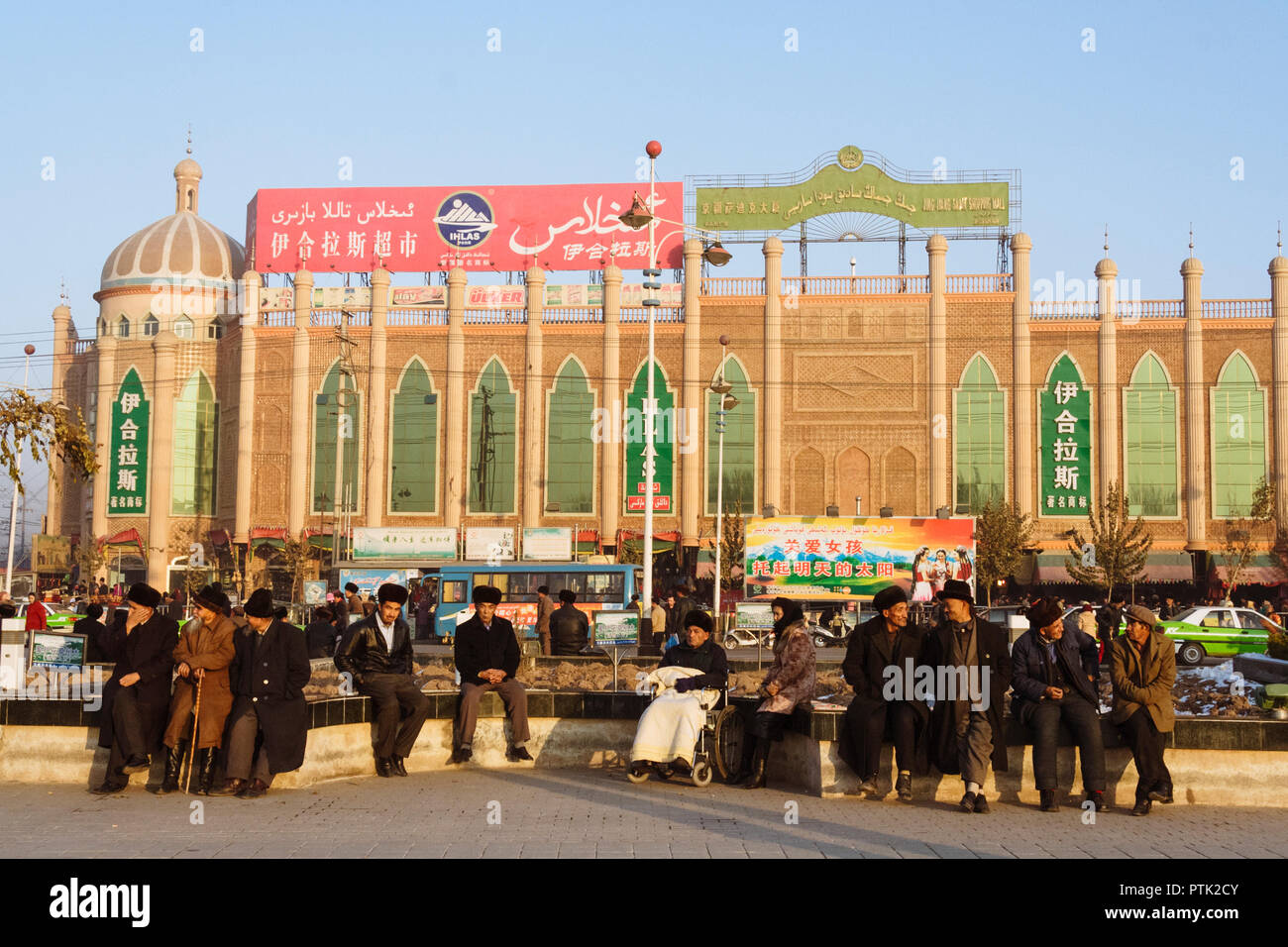 Kashgar, Xinjiang, China : Uyghur men sit and chat outside the Ihlas shopping mall in Kashgar. Stock Photo