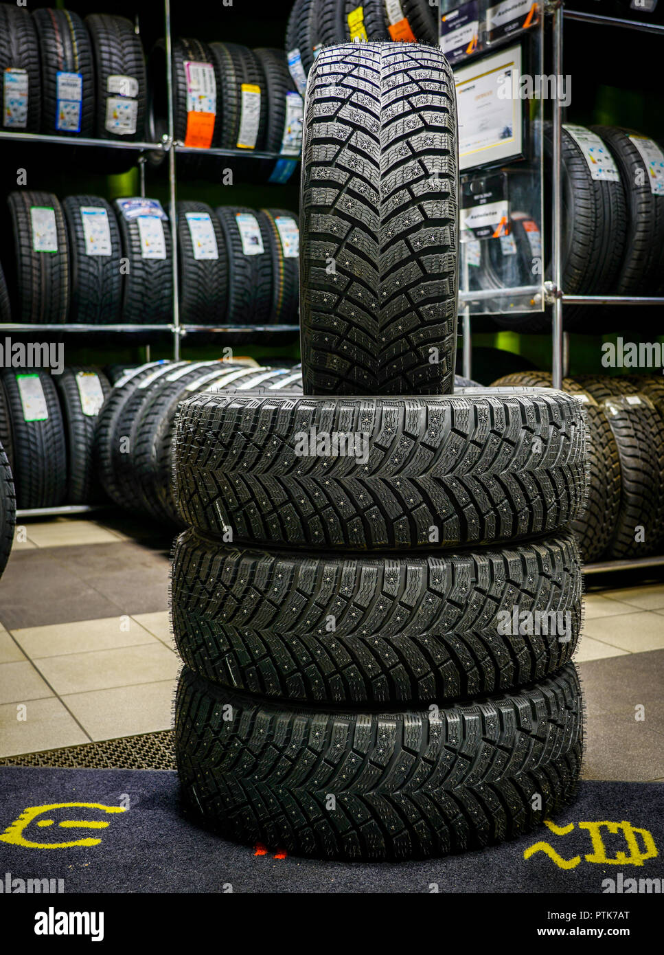 set of new winter tires with studs, tire shop in the background Stock Photo