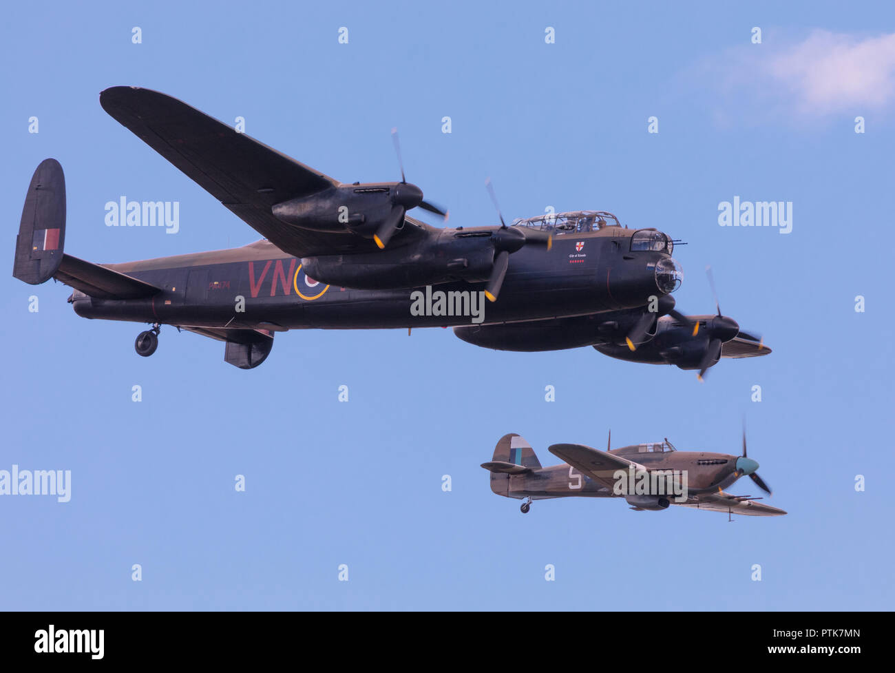 WWII Royal Air Force Avro Lancaster bomber escorted by Hawker Hurricane fighter at the IWM Duxford Air Show. Stock Photo