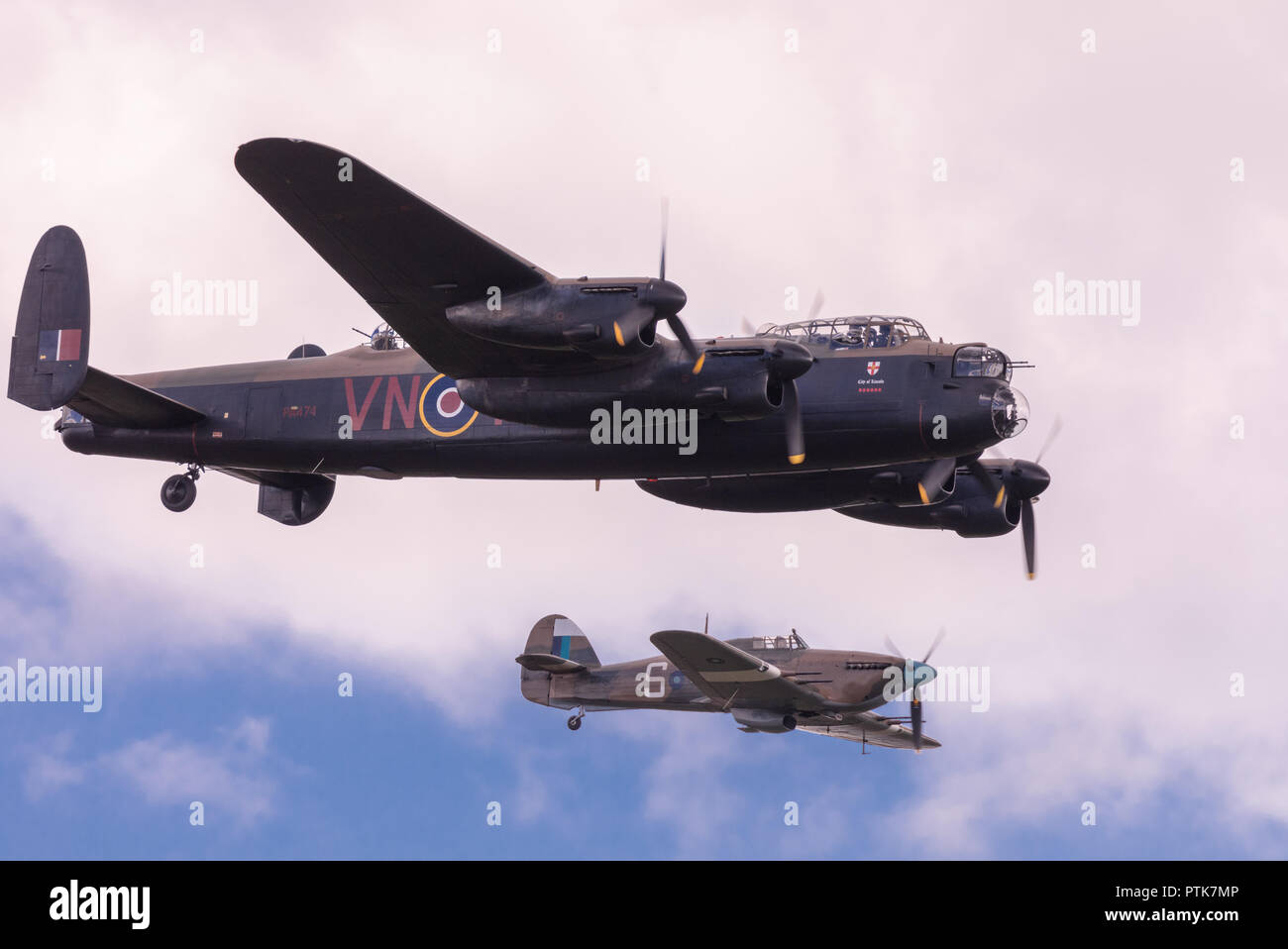 WWII Royal Air Force Avro Lancaster bomber escorted by Hawker Hurricane fighter at the IWM Duxford Air Show. Stock Photo