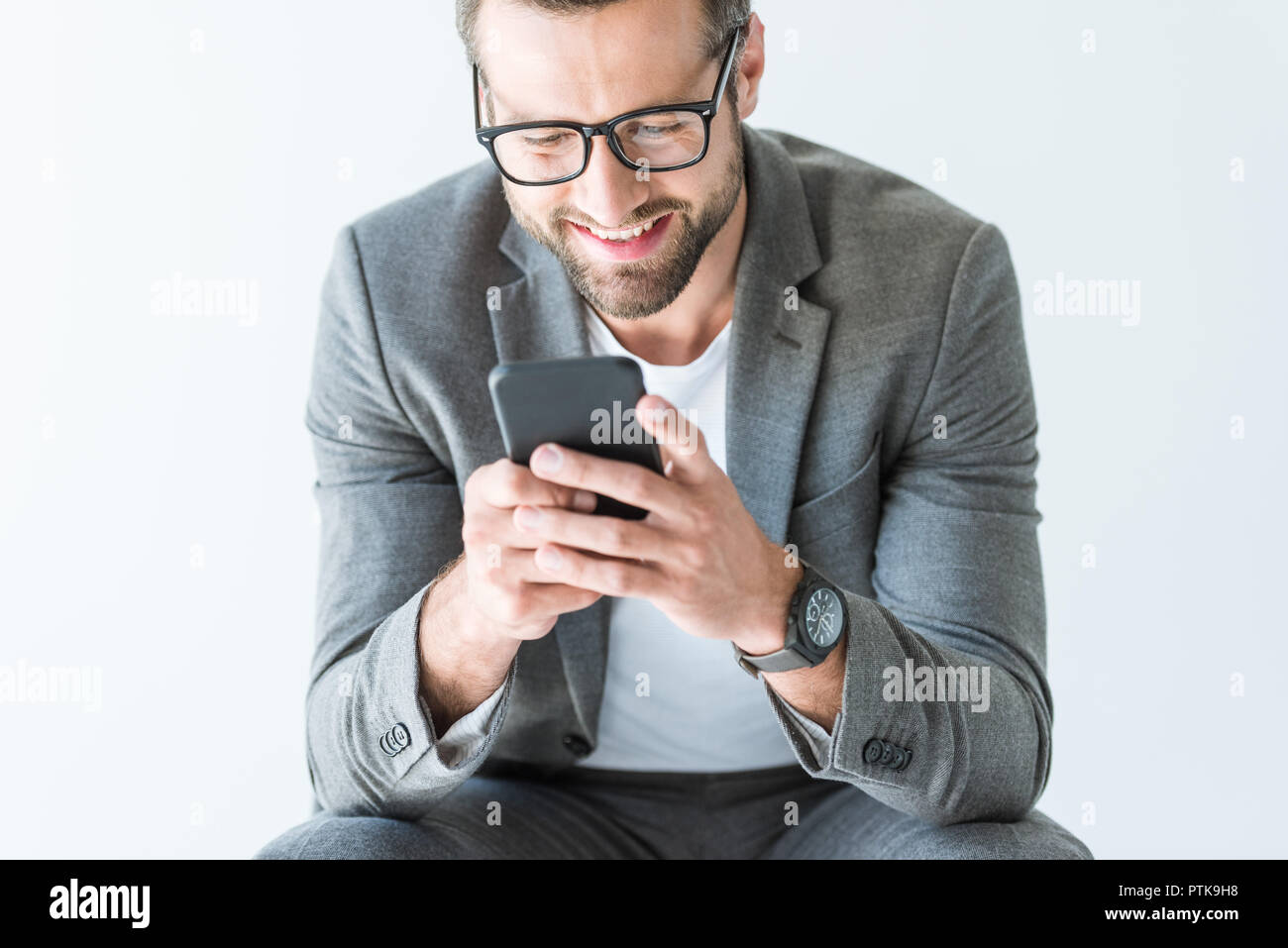 handsome smiling man in gray suit using smartphone, isolated on white Stock Photo