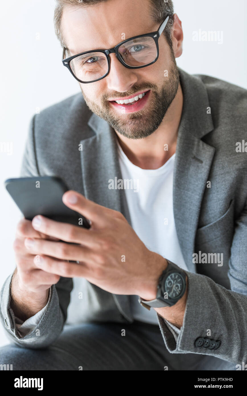 bearded smiling man in gray suit using smartphone, isolated on white Stock Photo