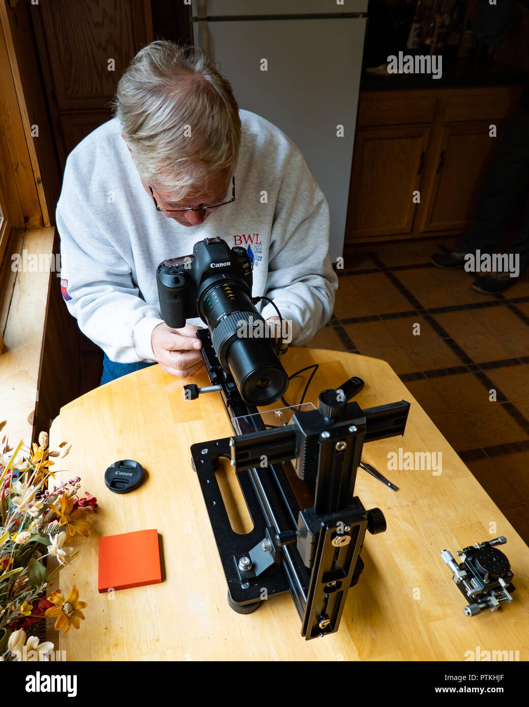 A senior photographer demonstrating techniques for photographing small insects with a Canon digital camera and lens. Stock Photo