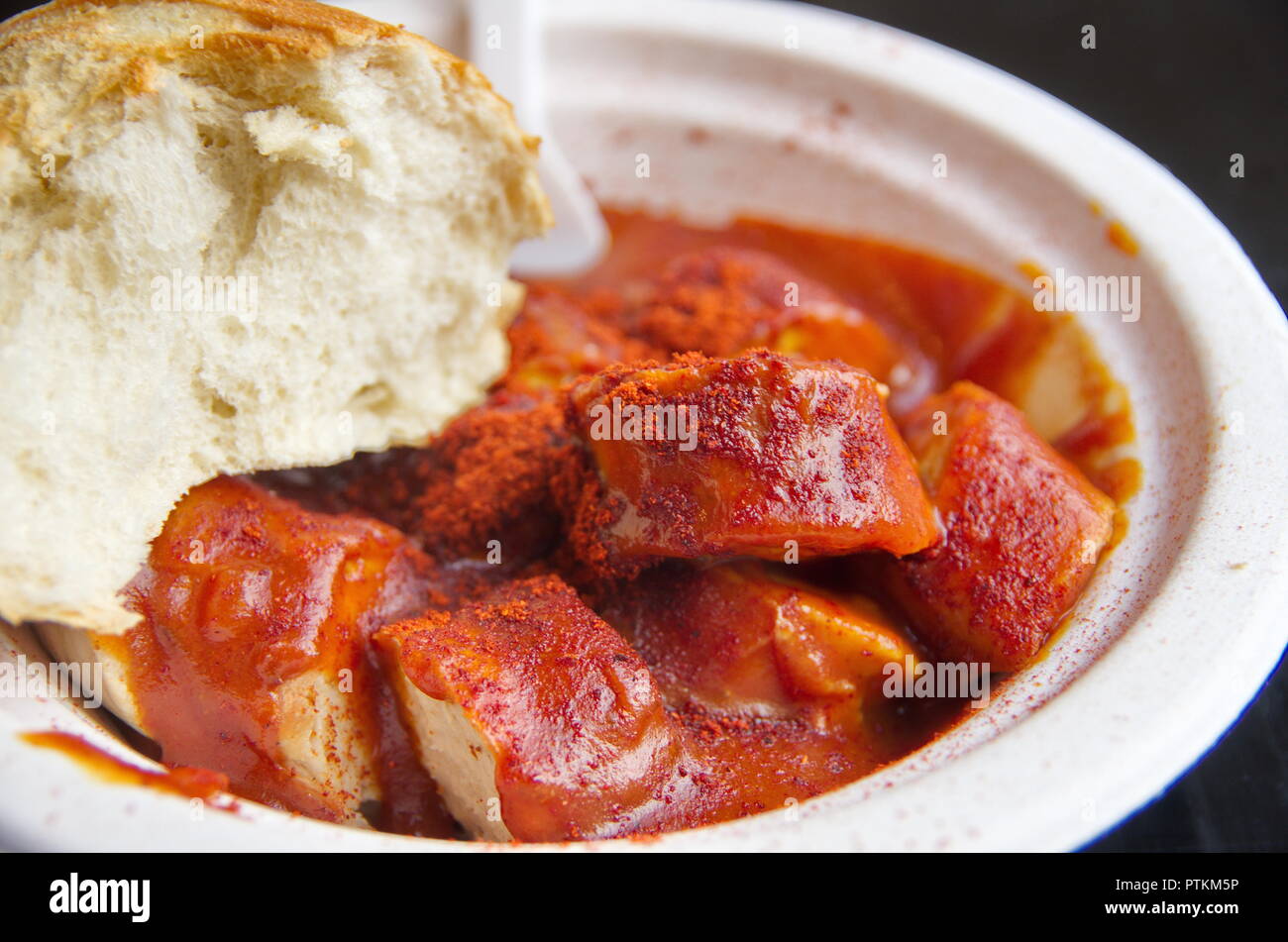 Scharfe Currywurst mit Brötchen Stock Photo