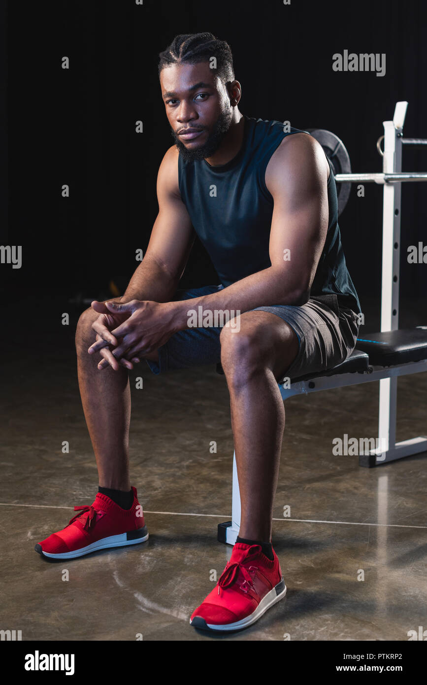 full length view of young african american sportsman sitting and ...