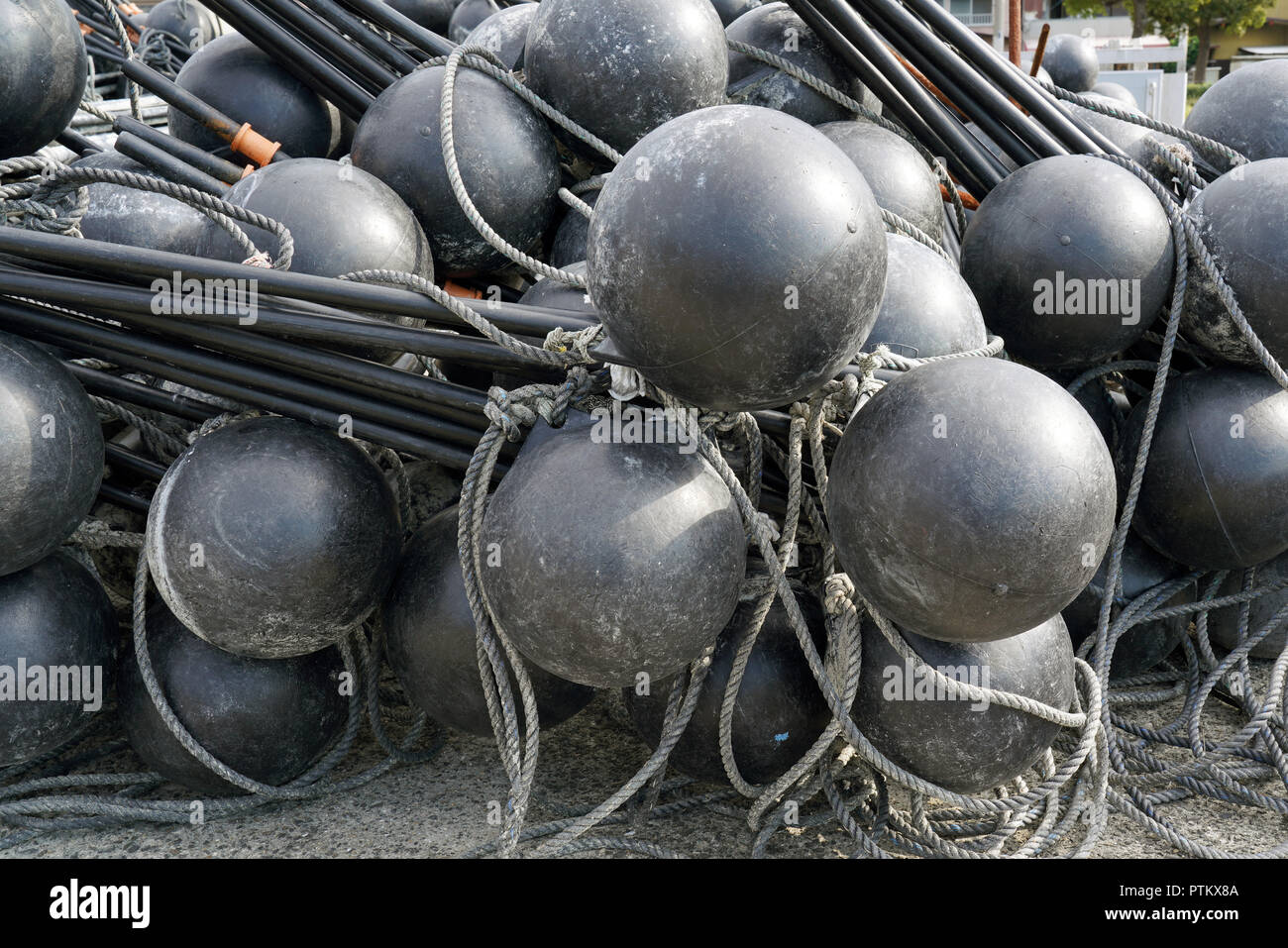 Black spherical plastic floats of fishing nets out of the water in port