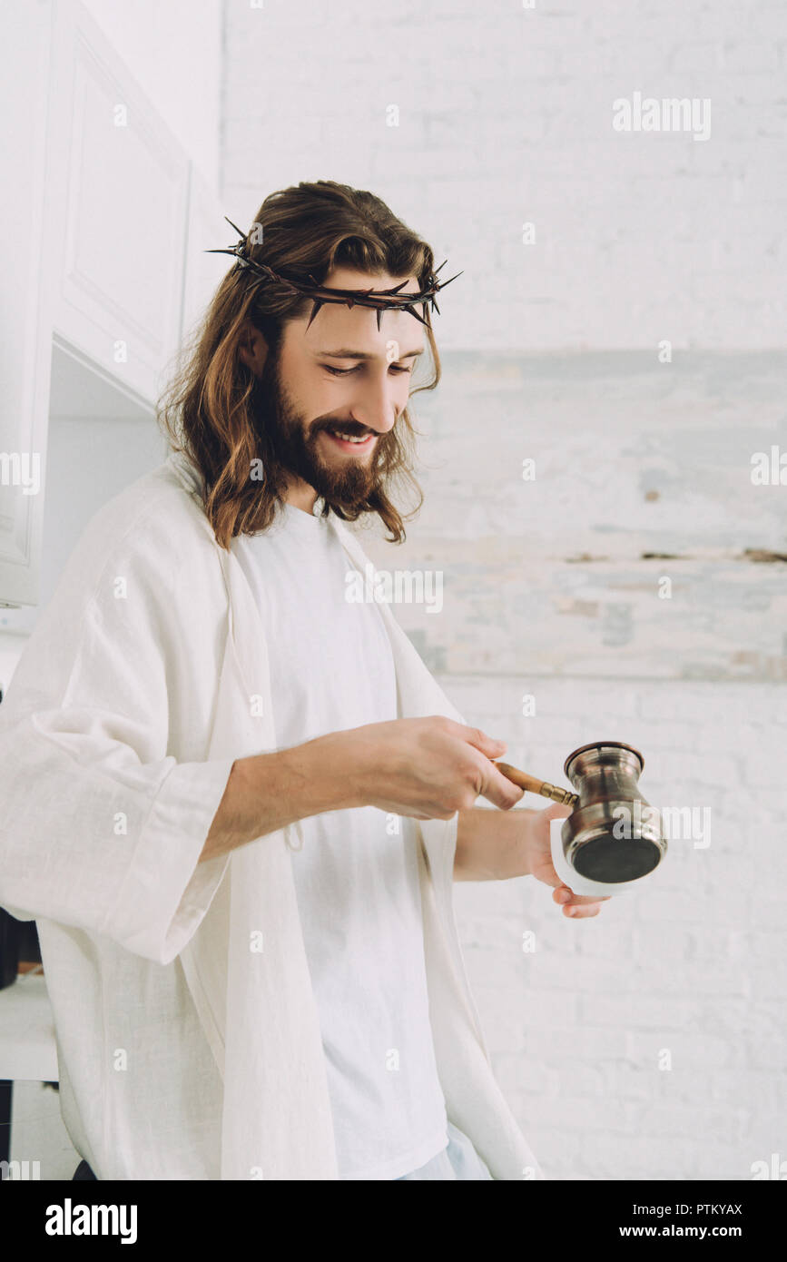 smiling Jesus pouring coffee from cezve into cup in kitchen during ...