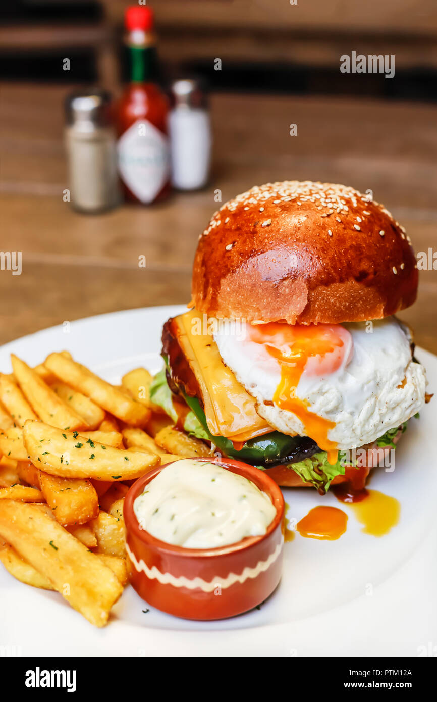 Freshly cooked burger with ground beef, cheddar cheese and fried with