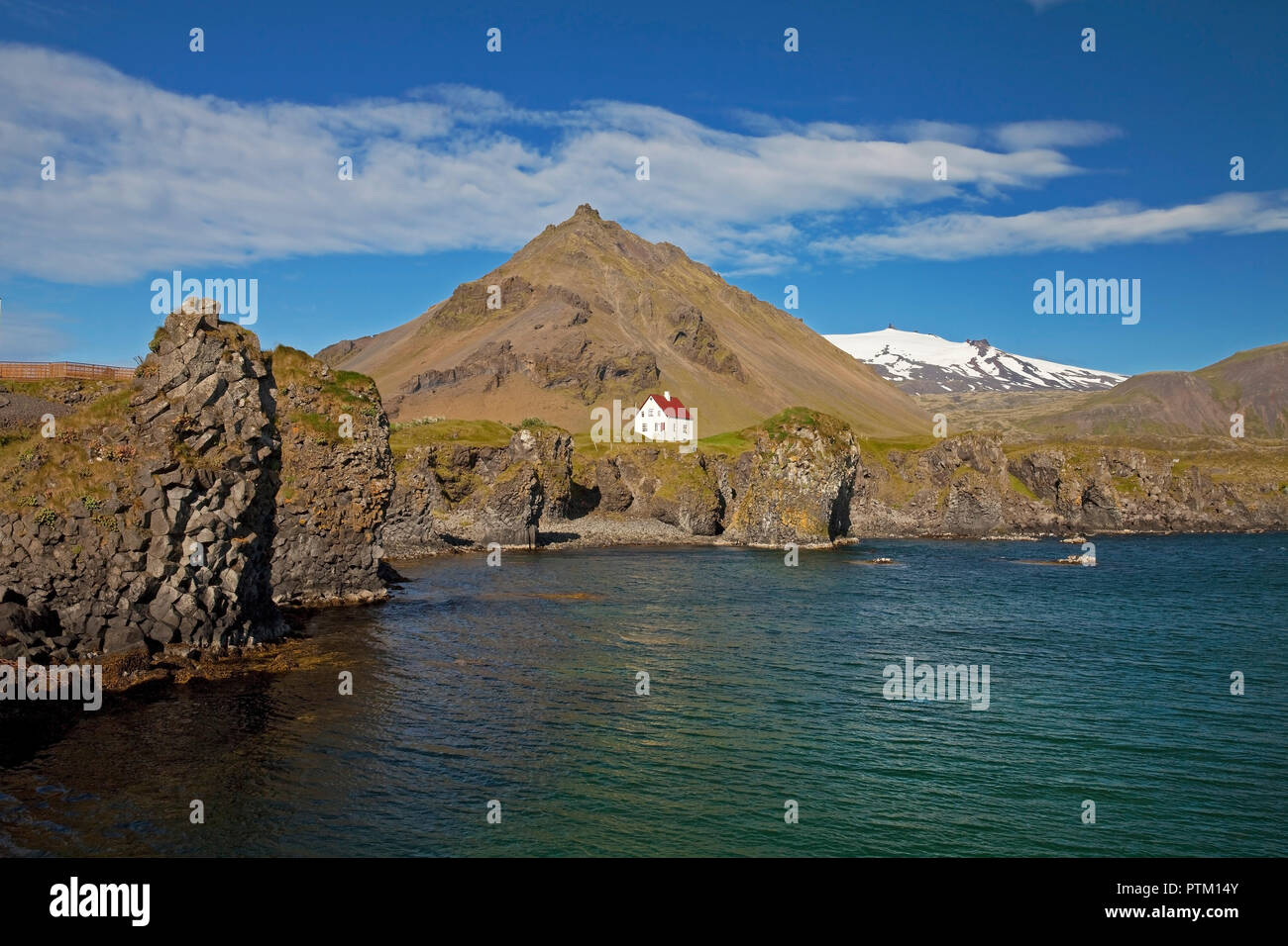 House on the basalt coast off Stapafell mountain and Snæfellsjoekull glacier, Arnarstapi, Snæfellsnes, Vesturland, Iceland Stock Photo