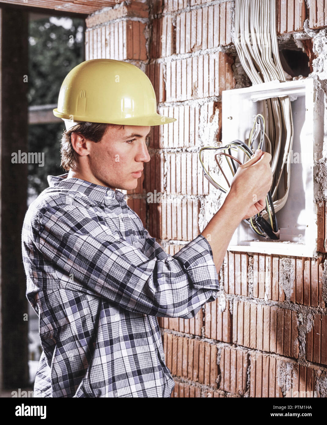 Bauarbeiter Elektriker Mit Schutzhelm Beim Verlegen Von Leitungen Auf Einer Baustelle Ziegelbau Neubau Modellfreigabe Stock Photo Alamy