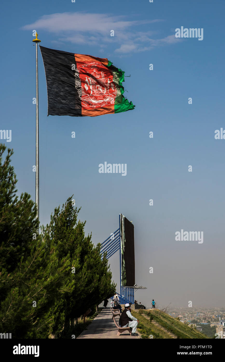 A huge flag of Afghanistan flies at the top of swimming pool hill overlooking Kabul. Stock Photo