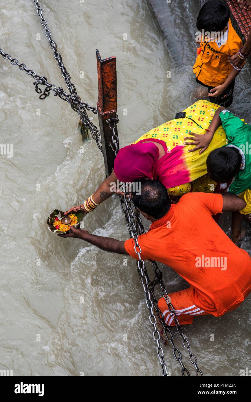 Pilgrims place an offering to the holy River Ganges during the Kenwar