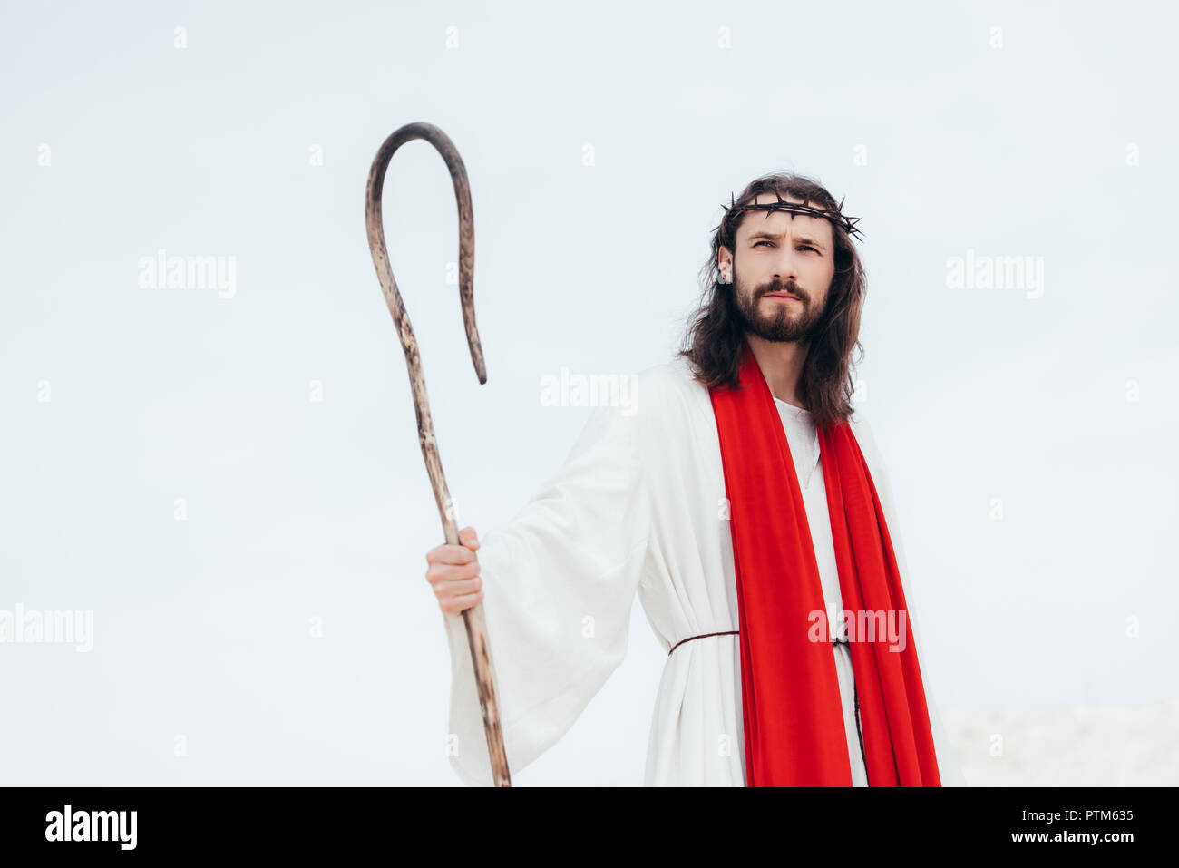 Jesus In Robe And Crown low angle view of Jesus in robe, red sash and crown of thorns standing ...