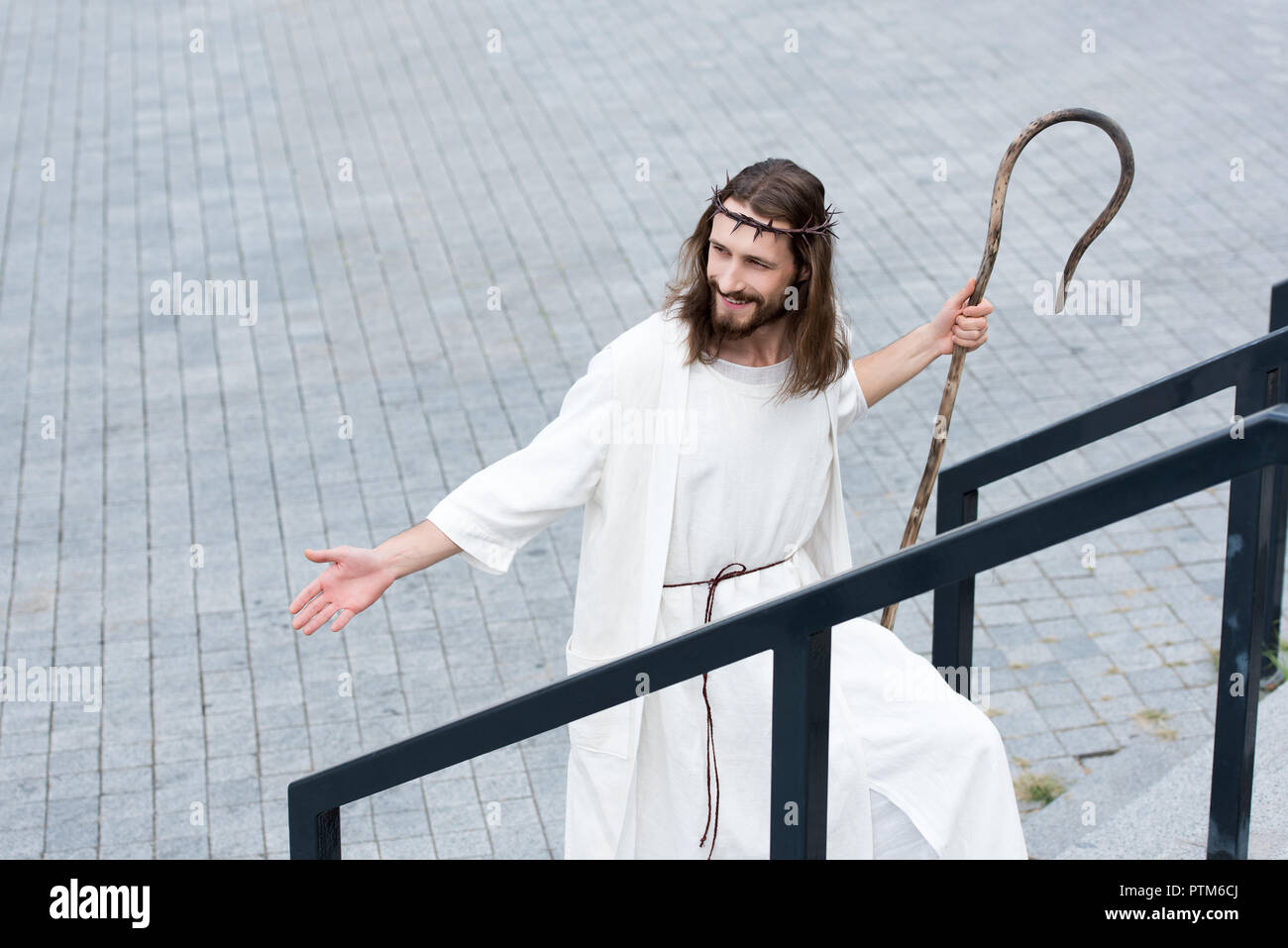 Jesus In Robe And Crown high angle view of cheerful Jesus in robe and crown of thorns walking ...