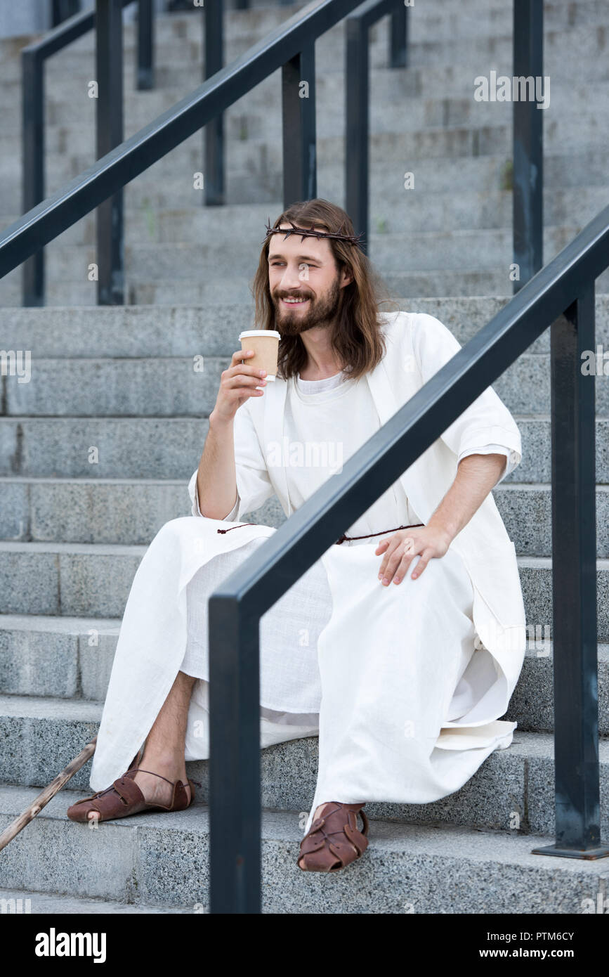 smiling Jesus in robe and crown of thorns sitting on stairs and ...