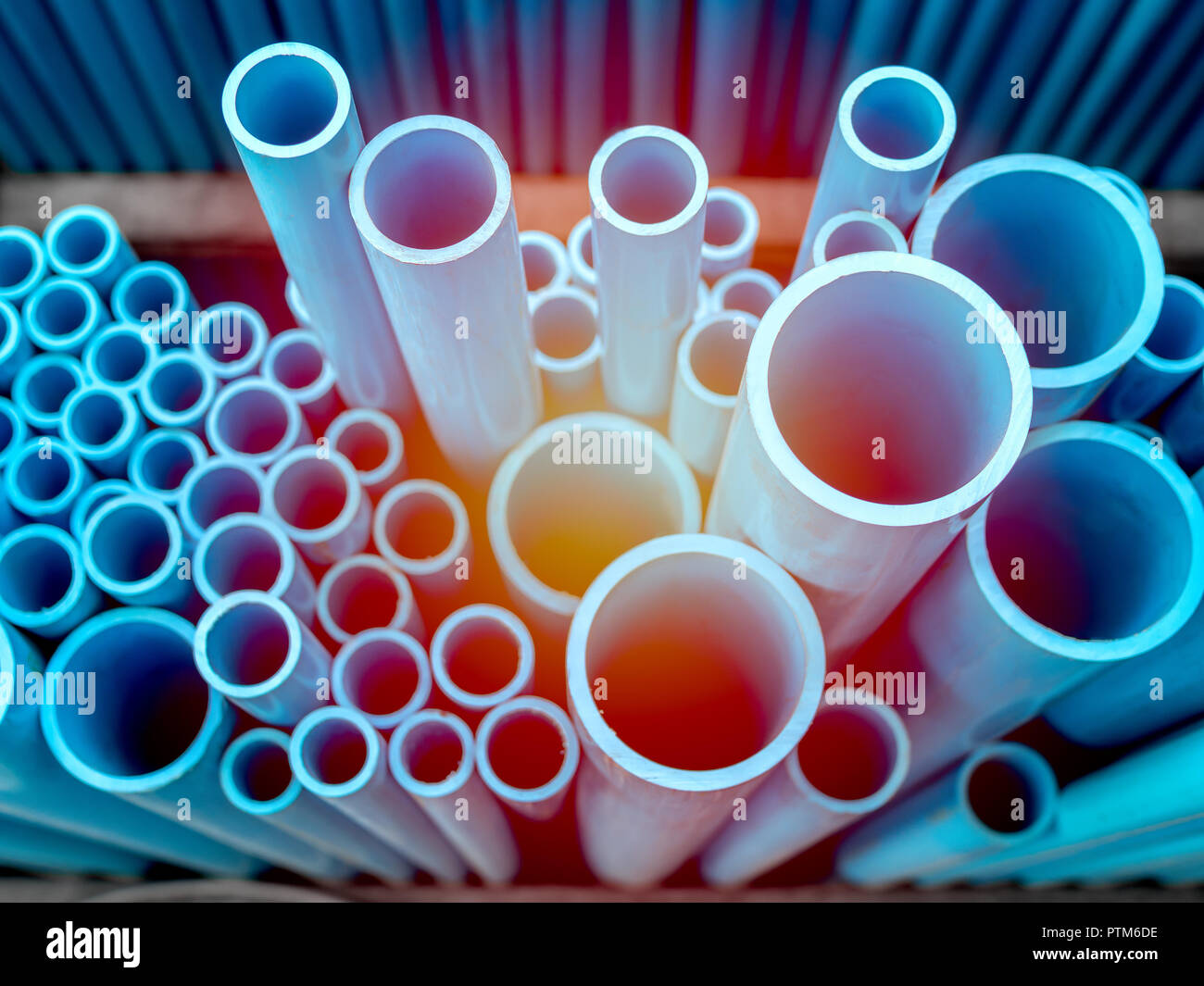 Tubes PVC pipes stacked in warehouse. Blue PVC pipes background with