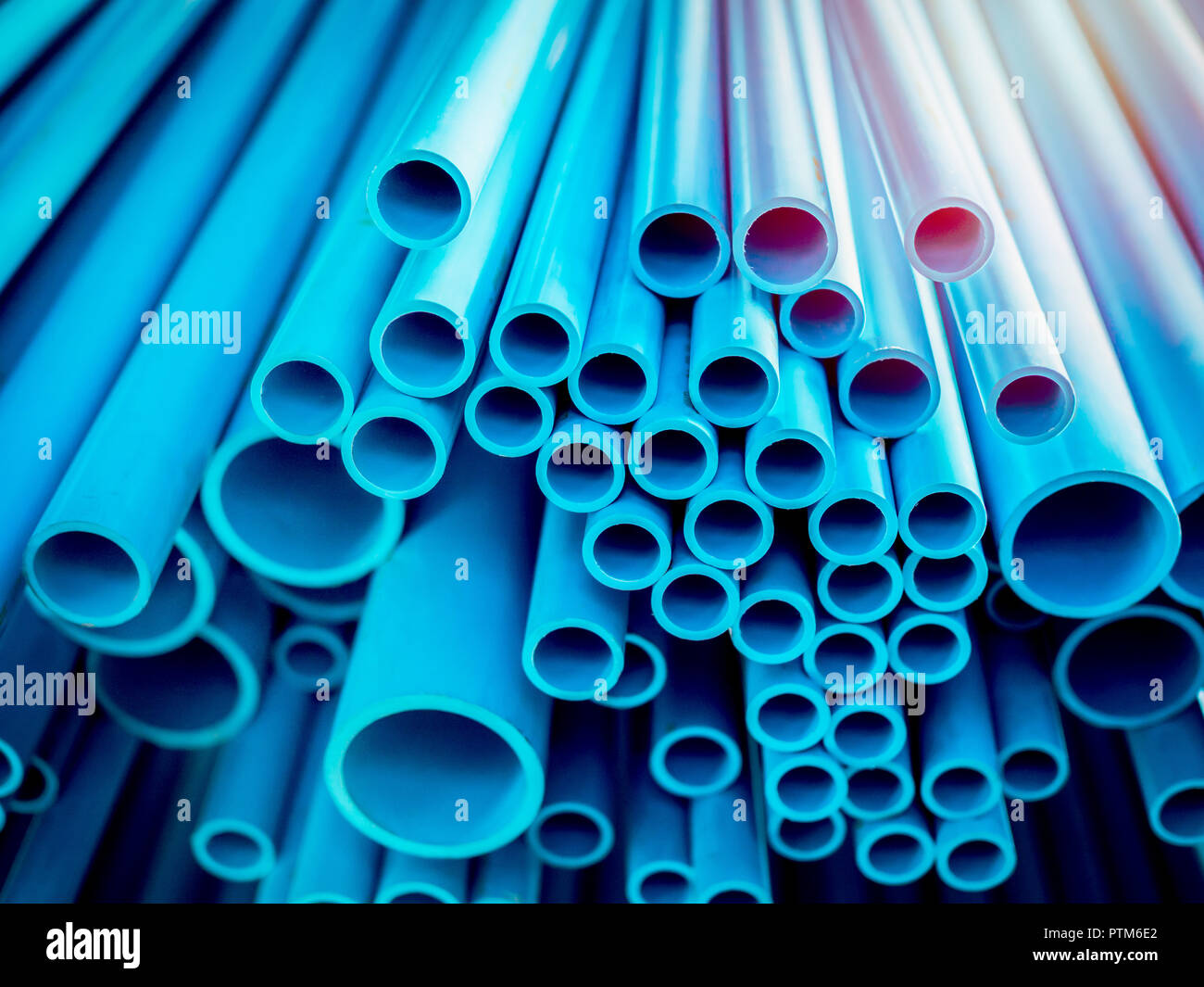 Tubes PVC pipes stacked in warehouse. Blue PVC pipes background with sunlight Stock Photo Alamy