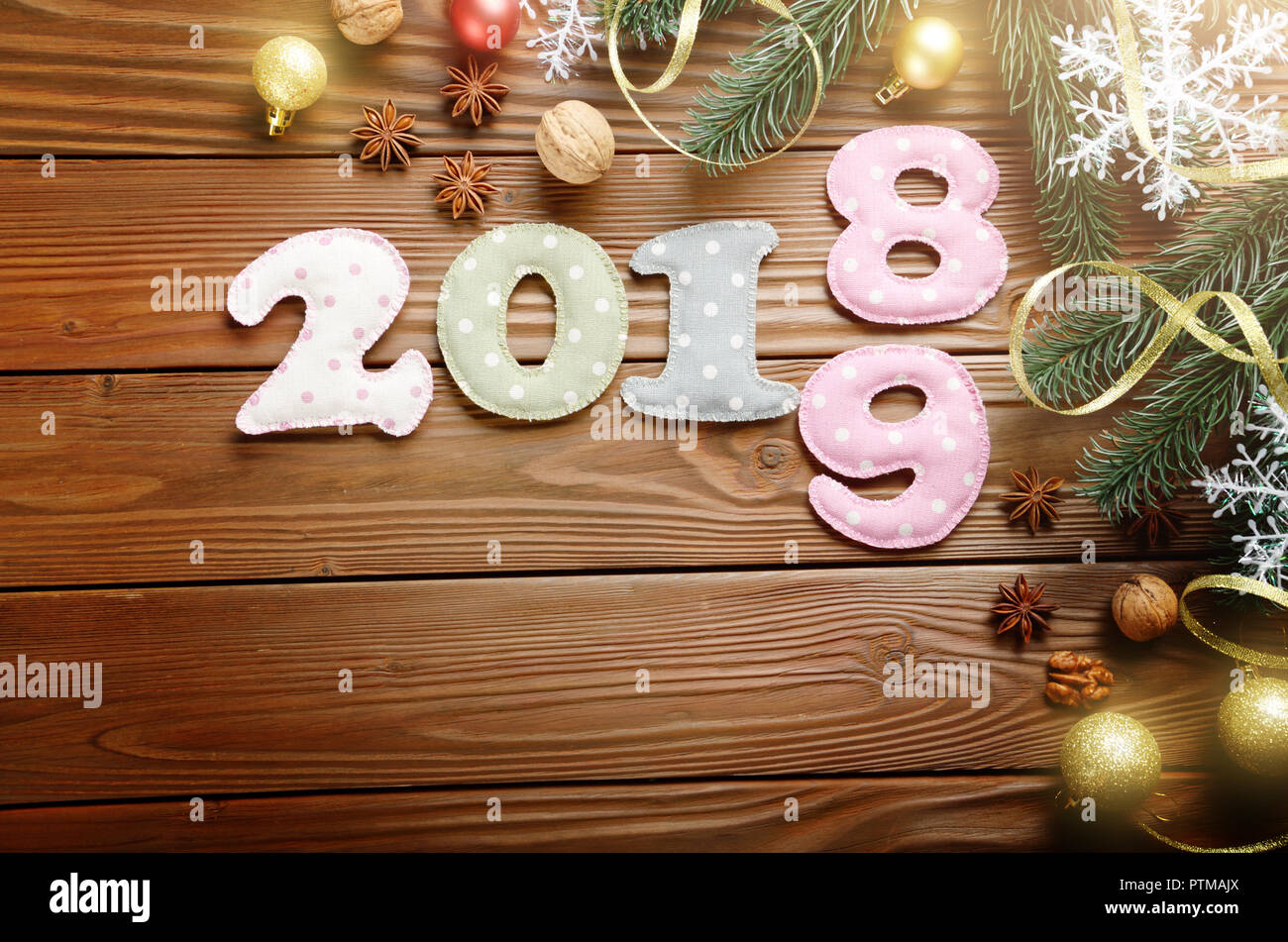 Colorful stitched digits 2 0 1 8 9 of polkadot fabric with Christmas decorations flat lyed on wooden background. Space for text Stock Photo