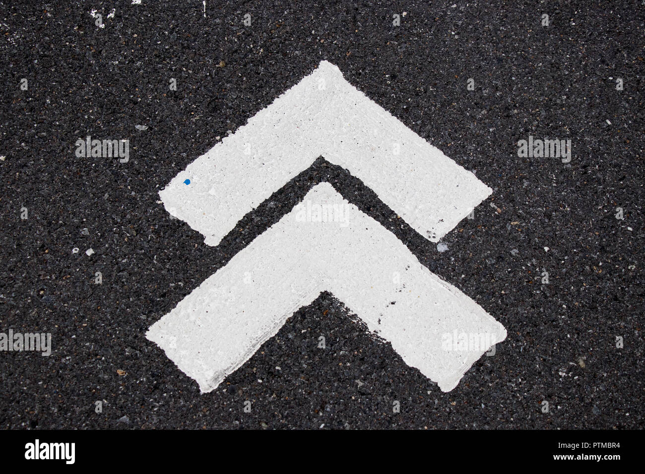 White painting in forward direction arrow symbol on black asphalt road background Stock Photo