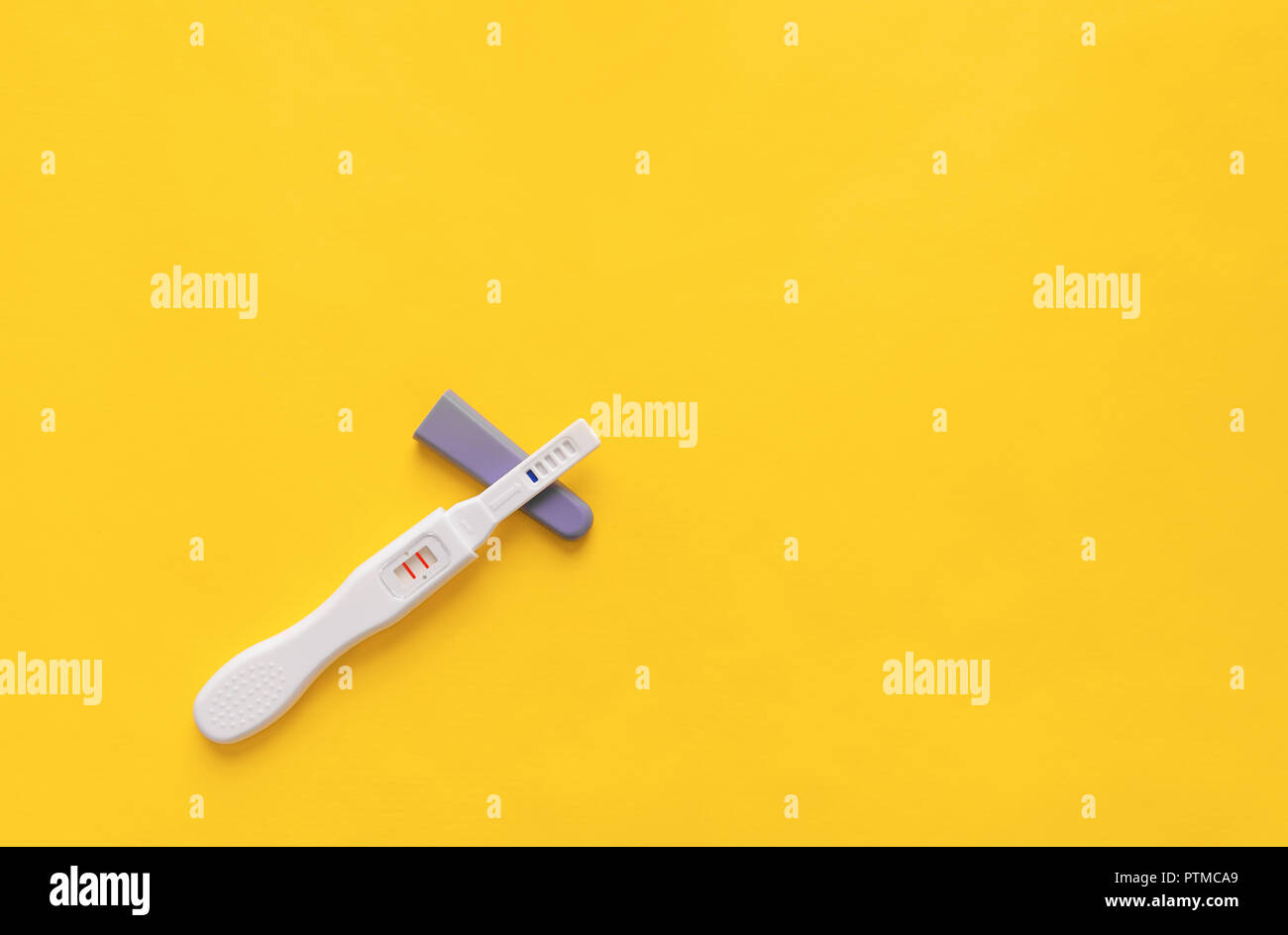 Pregnancy test on a yellow background. Close-up. Stock Photo