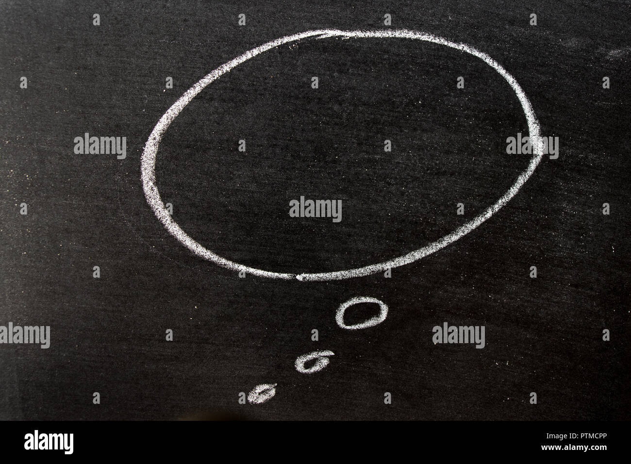 White color chalk hand drawing as speech bubble shape on black board ...