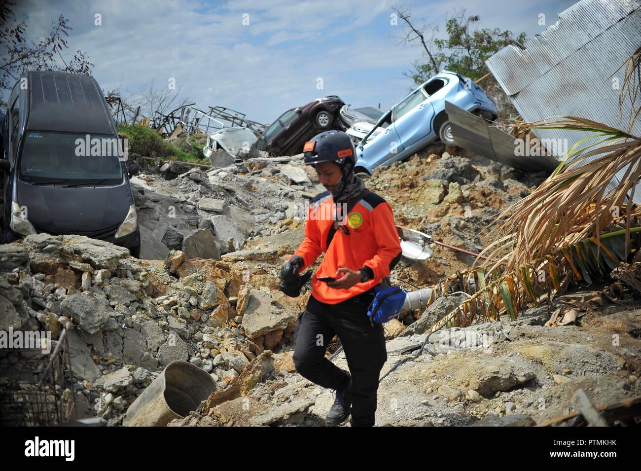 Poso, Indonesia. 9th Oct, 2018. An Indonesian rescuer walks on dried mud in Poso, Central Sulawesi Province, Indonesia, on Oct. 9, 2018. The earthquakes and the tsunami have killed at least 2,010 people, left over 5,000 others missing and triggered massive damage and a huge evacuation, according to the national disaster management agency. Credit: Zulkarnain/Xinhua/Alamy Live News Stock Photo