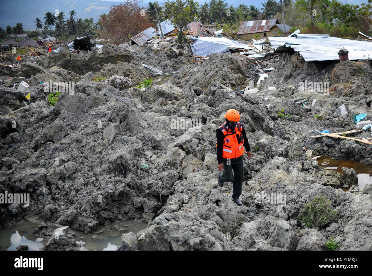 Poso, Indonesia. 9th Oct, 2018. An Indonesian rescuer walks on dried mud in Poso, Central Sulawesi Province, Indonesia, on Oct. 9, 2018. The earthquakes and the tsunami have killed at least 2,010 people, left over 5,000 others missing and triggered massive damage and a huge evacuation, according to the national disaster management agency. Credit: Zulkarnain/Xinhua/Alamy Live News Stock Photo