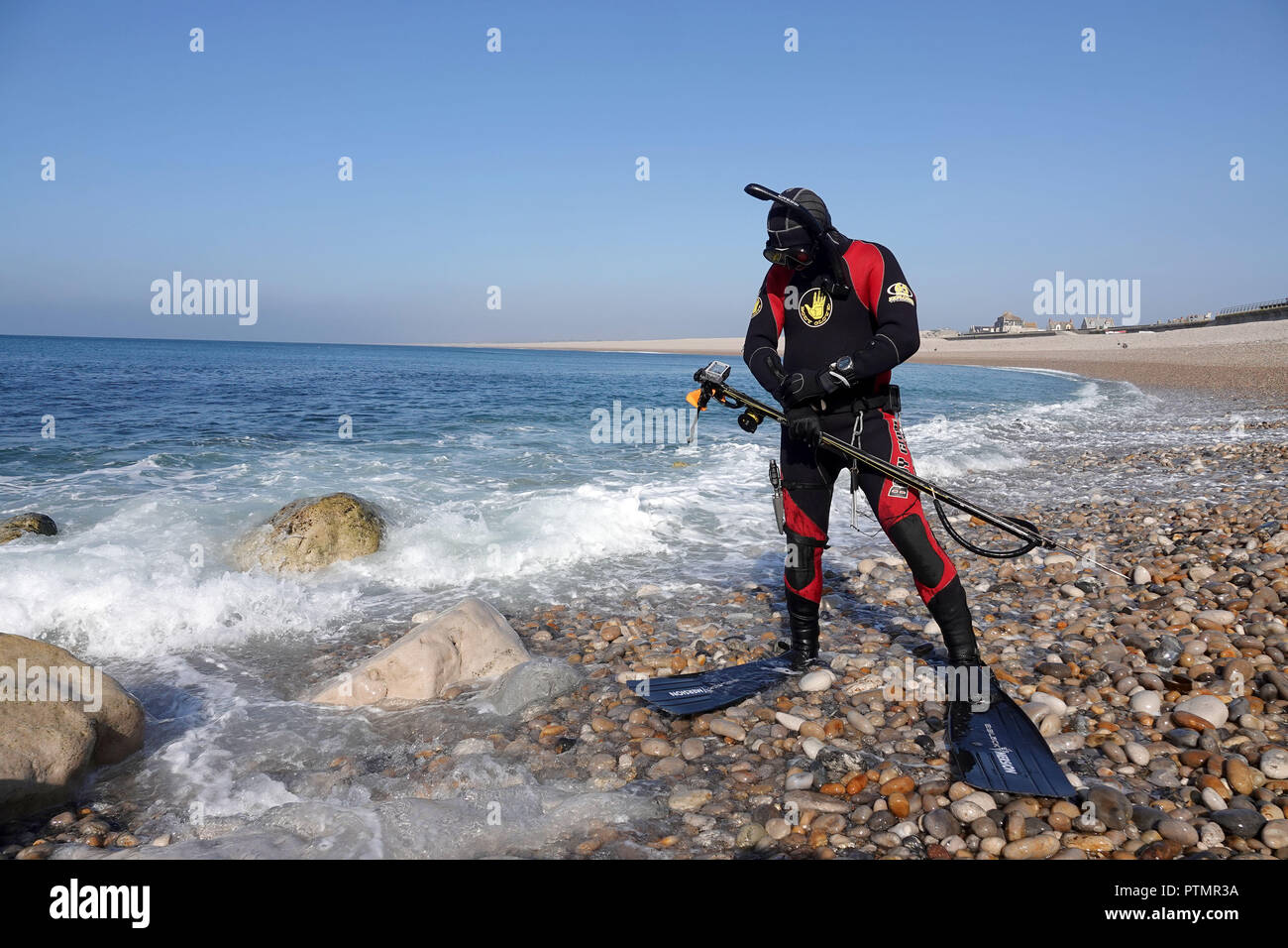 Chesil Beach, Dorset. 10th Oct 2018. UK Weather: A spearfishing diver with a speargun enjoys the unseasonal weather at Chesil Beach, Portland in Dorset Credit: Finnbarr Webster/Alamy Live News Stock Photo