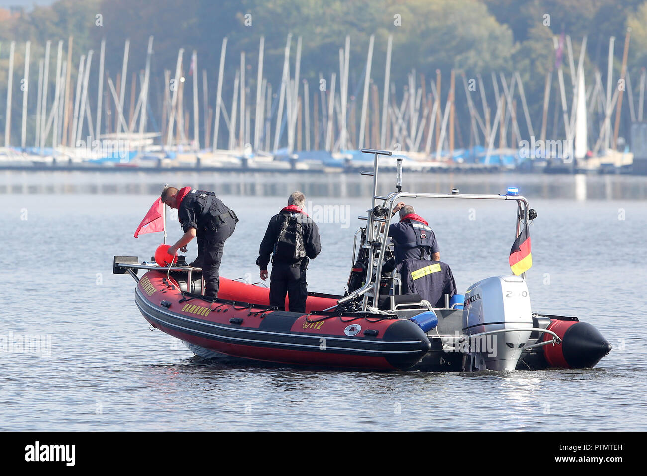 10 October 2018, Hamburg: The task forces of the explosive ordnance clearance service are standing in a boat during the recovery of two World War II grenades in the area of the Lombards Bridge. According to the fire department, divers from the explosive ordnance clearing service had identified an explosive grenade as well as a rifle grenade with a so-called picric acid igniter. Especially the latter was dangerous according to the fire brigade spokesman, so that it was decided to blow up both grenades controlled. Photo: Bodo Marks/dpa Stock Photo