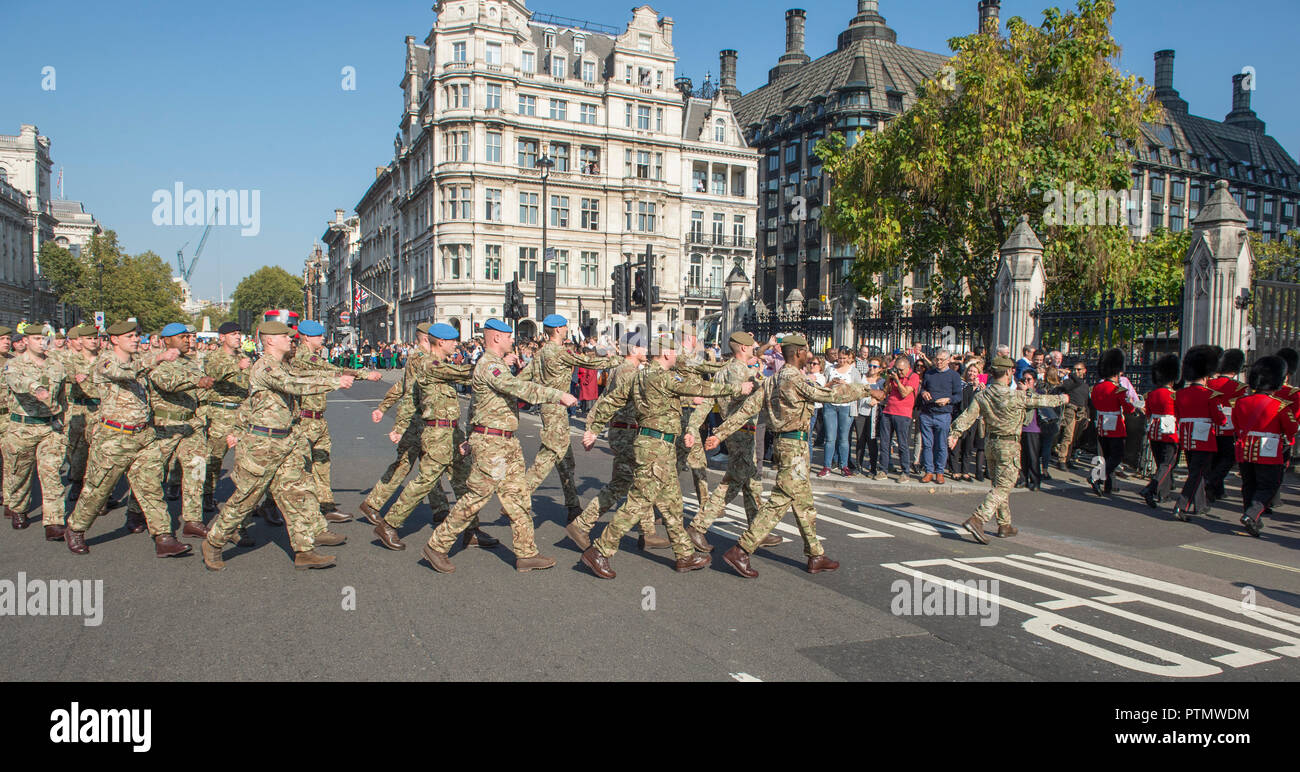 Westminster, London, UK. 10 October, 2018. The Army march to Parliament to be thanked by Parliament for service in not one theatre of operations, but in 55 countries and involves a contingent of 120 Army personnel – a distillation of the 51,726 soldiers who deployed last year to more than 55 countries on operations, defence engagement and training, and the 25,000 troops held in readiness to deploy at any moment. They arrive at Parliament accompanied by the world-famous Band of the Grenadier Guards in full ceremonial dress. Credit: Malcolm Park editorial/Alamy Live News Stock Photo