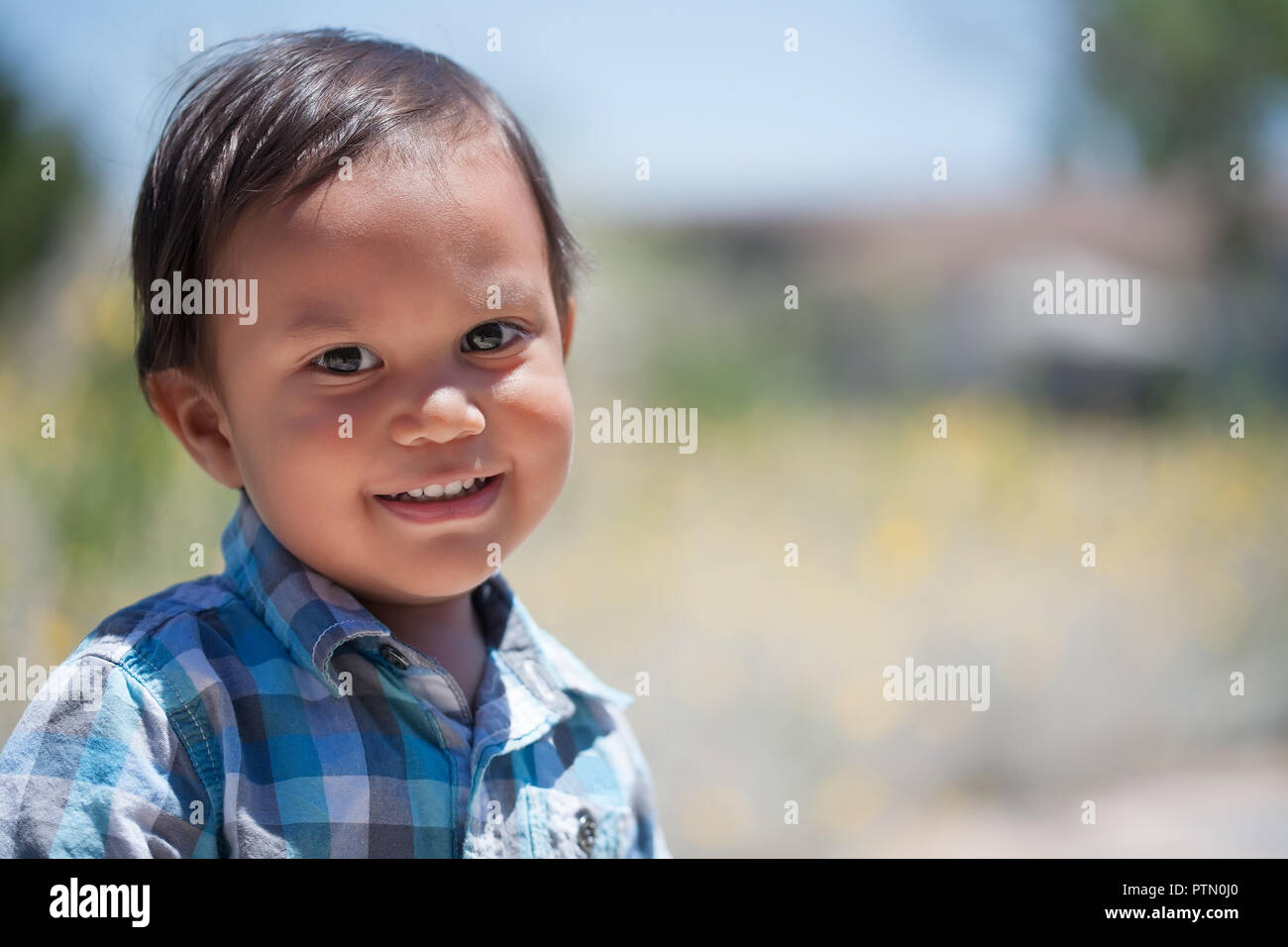 Handsome toddler boy with pleasant smile and bright eyed, looking optimistic and eager to play during summer Stock Photo