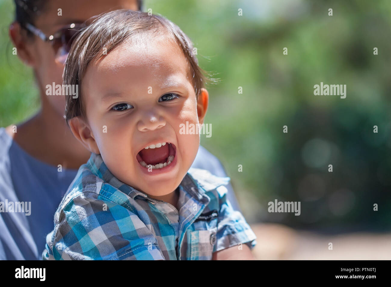 Cute young boy with latino mother having fun outdoors enjoying parenthood and looking healthy Stock Photo