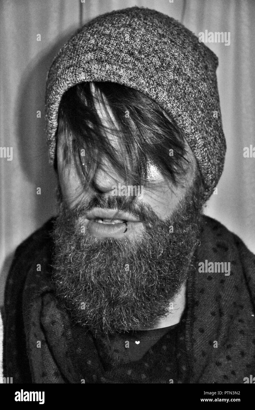 Bearded man, looking away. Beard, surf, piercing, smile. Stock Photo