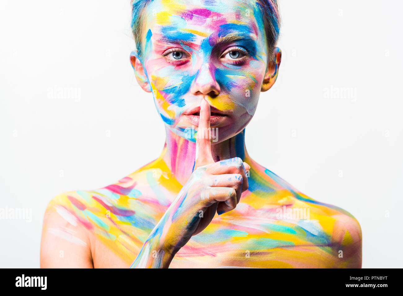 attractive girl with colorful bright body art showing silence gesture isolated on white Stock Photo