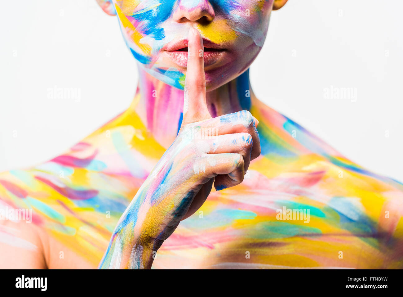 cropped image of girl with colorful bright body art showing silence gesture isolated on white Stock Photo