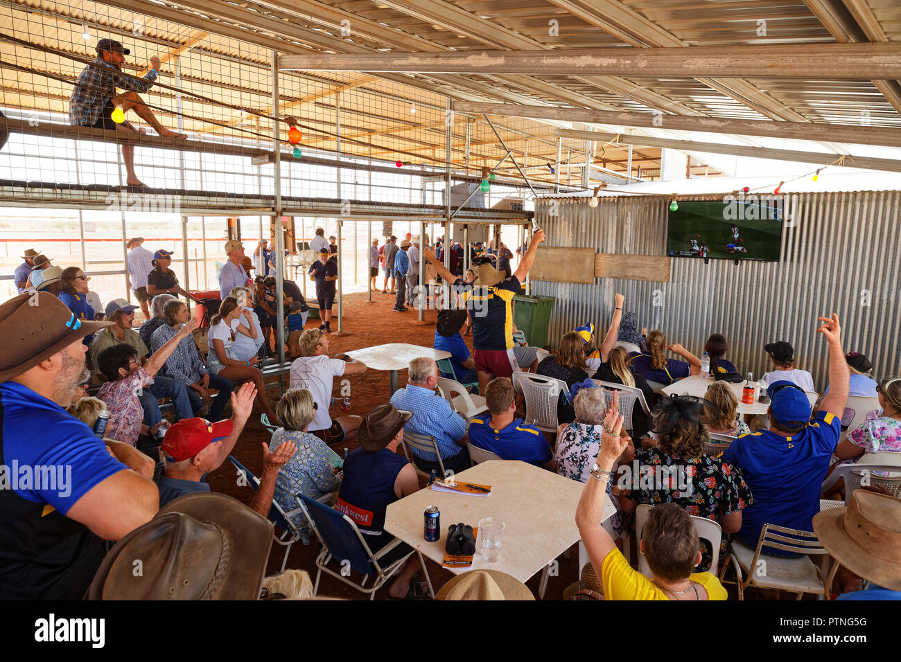 Spectators watch  the AFL grand final before horse races at Landor, 1000km north of Perth, Western Australia. Stock Photo