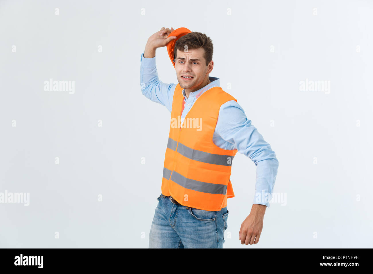 Young man wearing architect outfit and helmet with angry face, negative ...