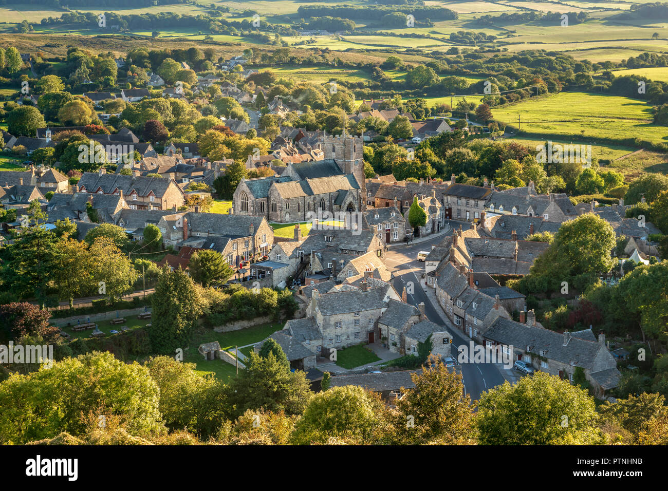 Corfe Village in Dorset, bathed in late afternoon sunshine as seen from East Hill Stock Photo