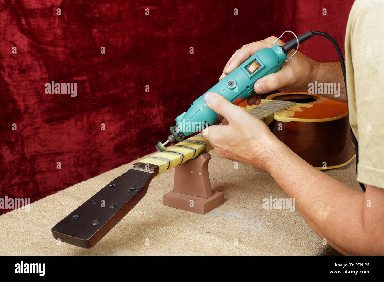 Musical instrument guitar repair and service - Worker polishing guitar neck  frets dremel and paste GOI Stock Photo - Alamy