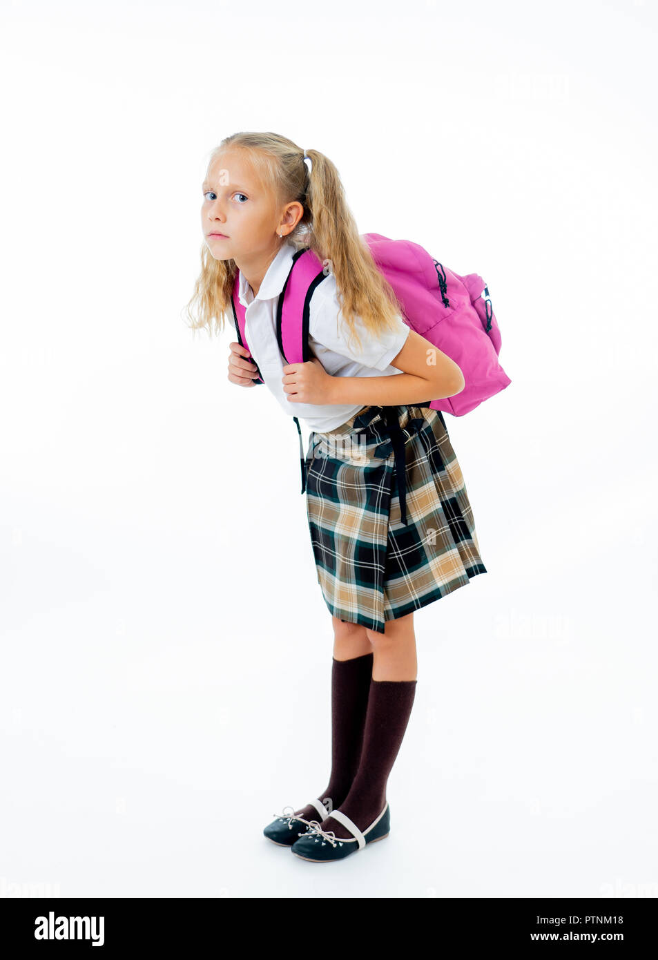 Sweet little girl in uniform carrying heavy big pink backpack or school