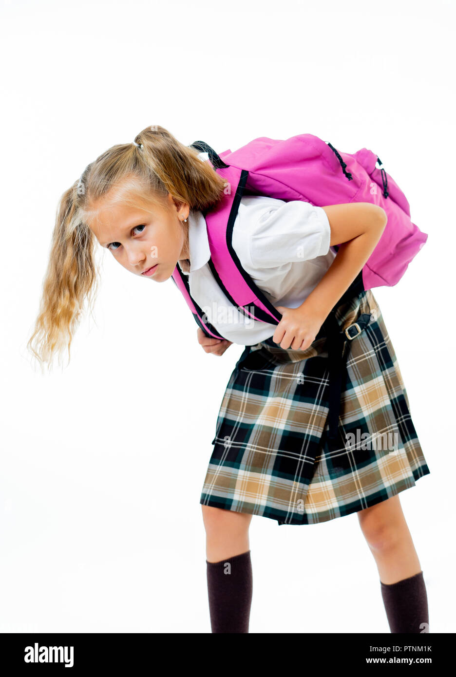 Sweet little girl in uniform carrying heavy big pink backpack or school