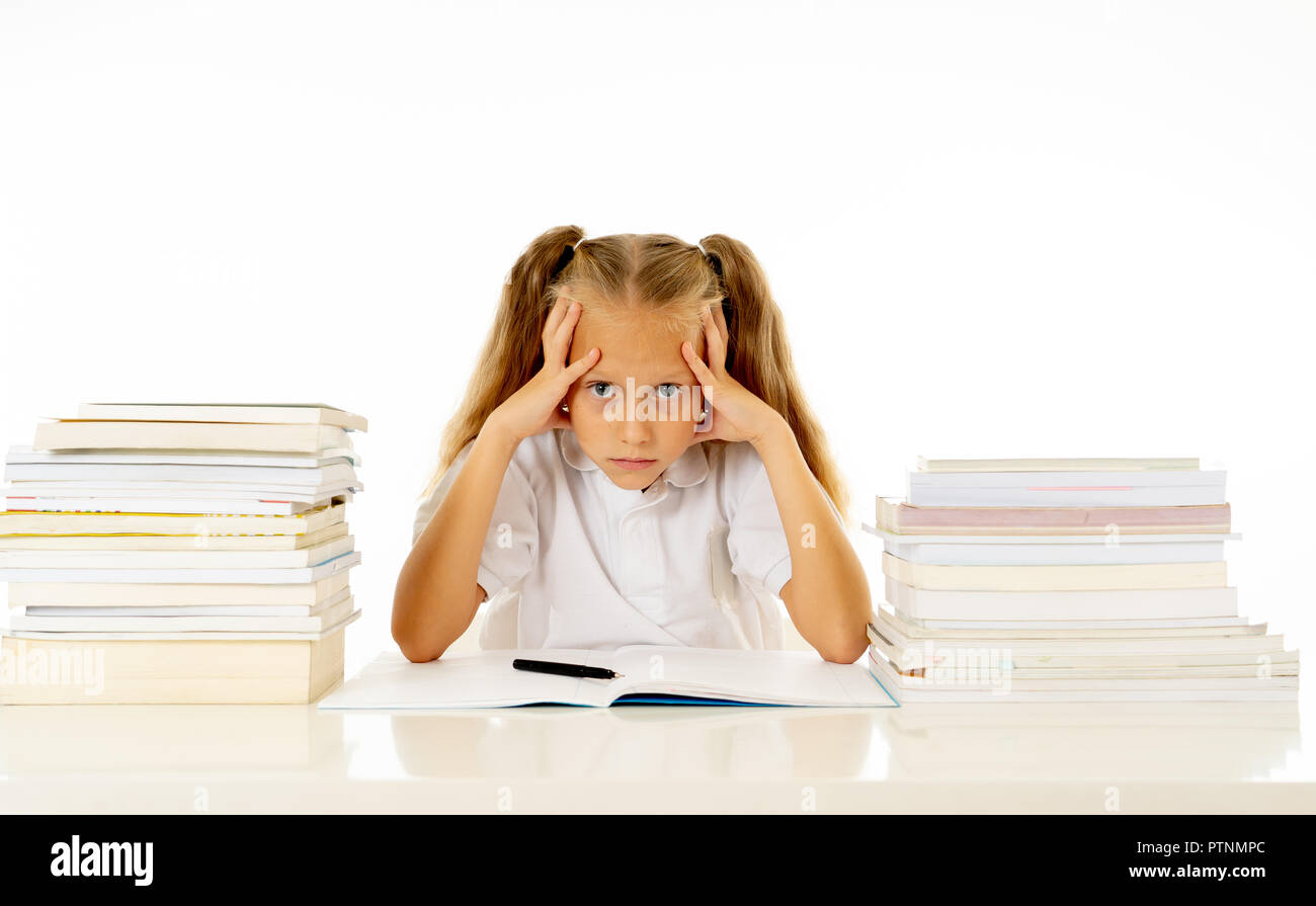 Sad and tired cute schoolgirl with blond hair sitting in stress doing ...