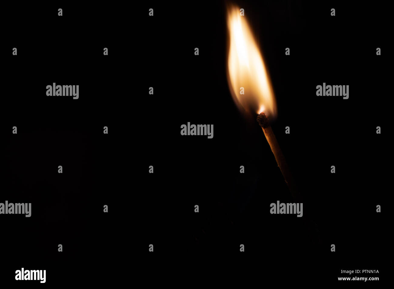 Match with strongly flaring flame on a black background closeup Stock Photo