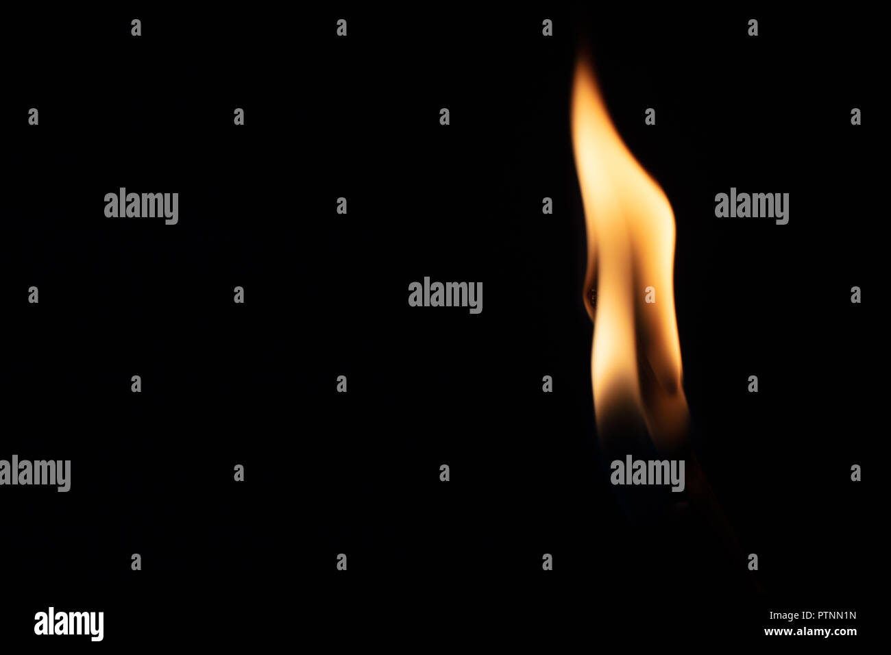 Match with strongly flaring flame on a black background closeup Stock Photo